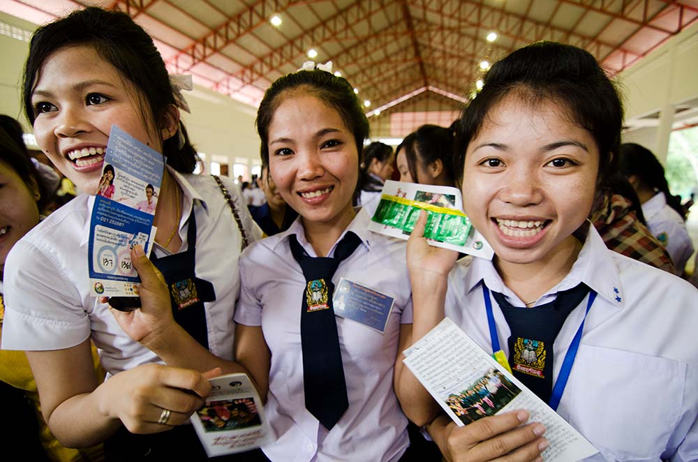 three young women smile with CSE material in hand