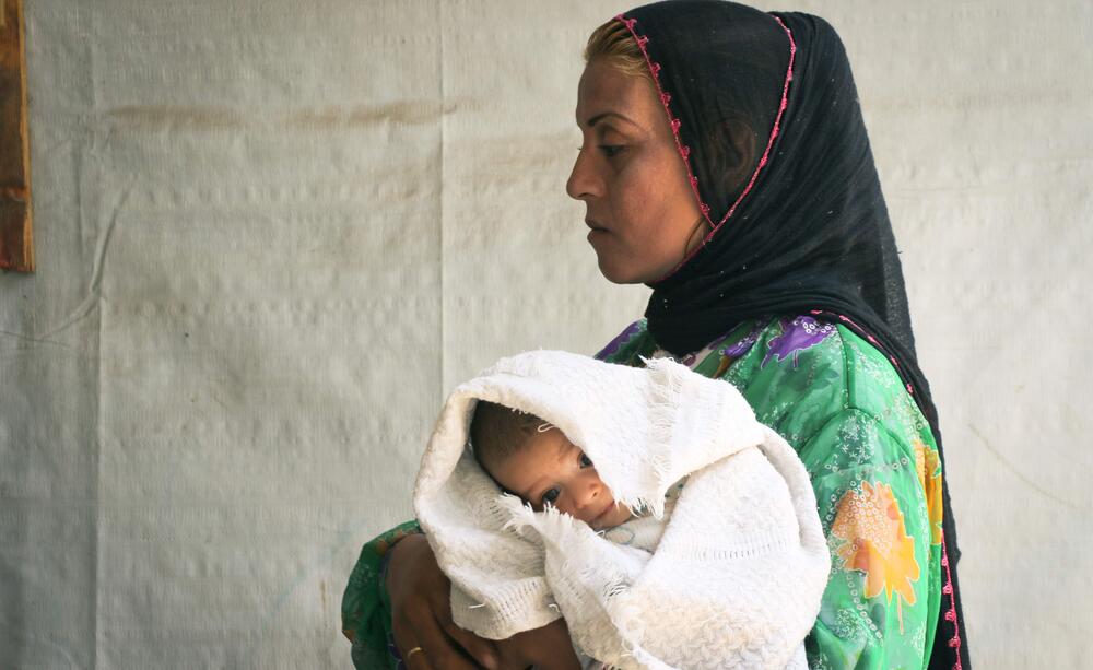 امرأة تحمل طفلها حديث الولادة.