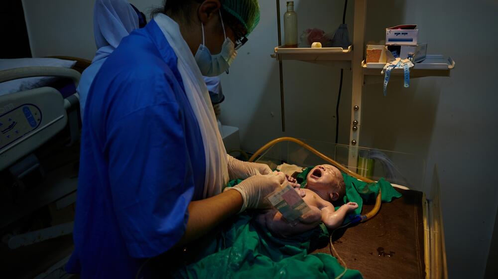 A nurse assists a baby.