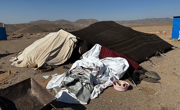 A family takes shelter in a tent in the Ghar Moshak Village.