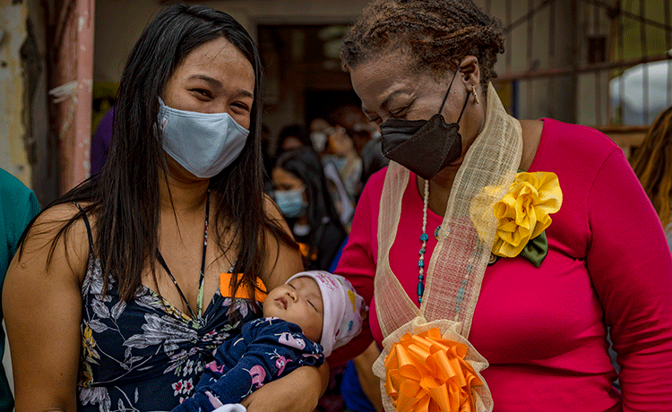 Mujer sosteniendo a un bebé junto a la Directora Ejecutiva del UNFPA