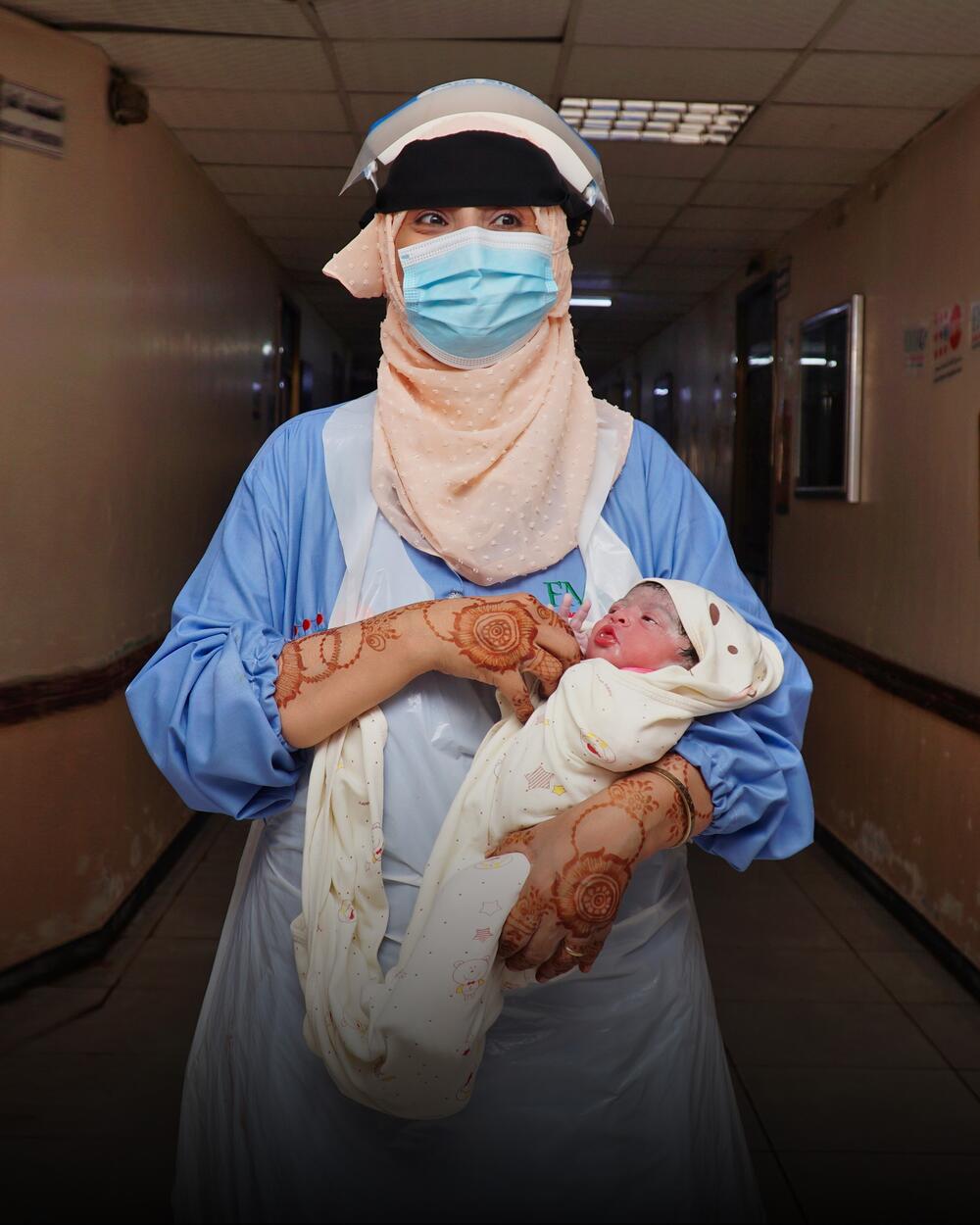 A midwife holds a new born infant. 