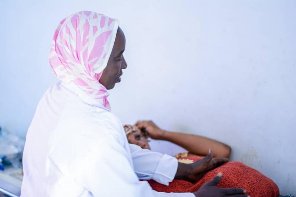 A midwife at the Ardamata clinic attends to a pregnant woman.