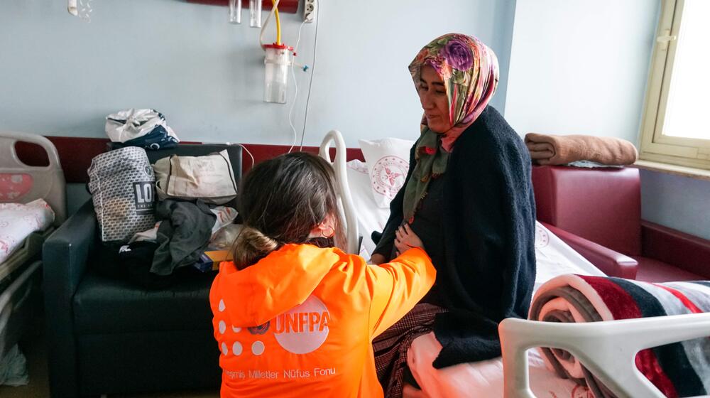 A woman receives help from UNFPA staff.