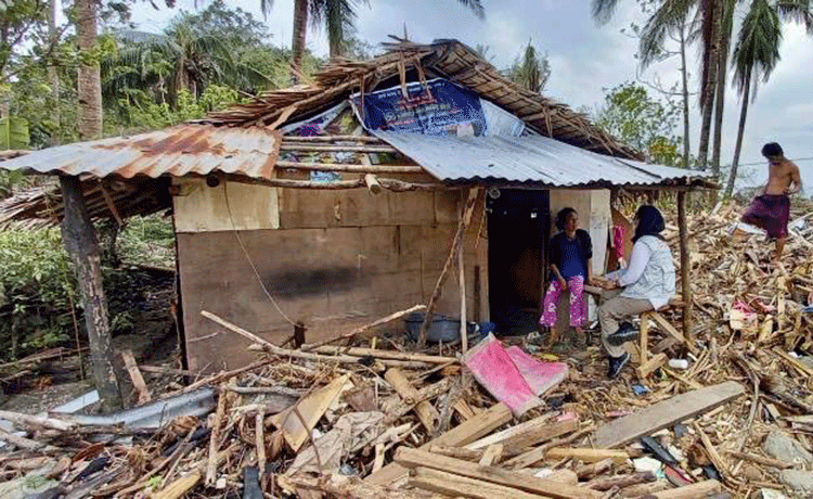 Una mujer sentada en una casa dañada en Filipinas