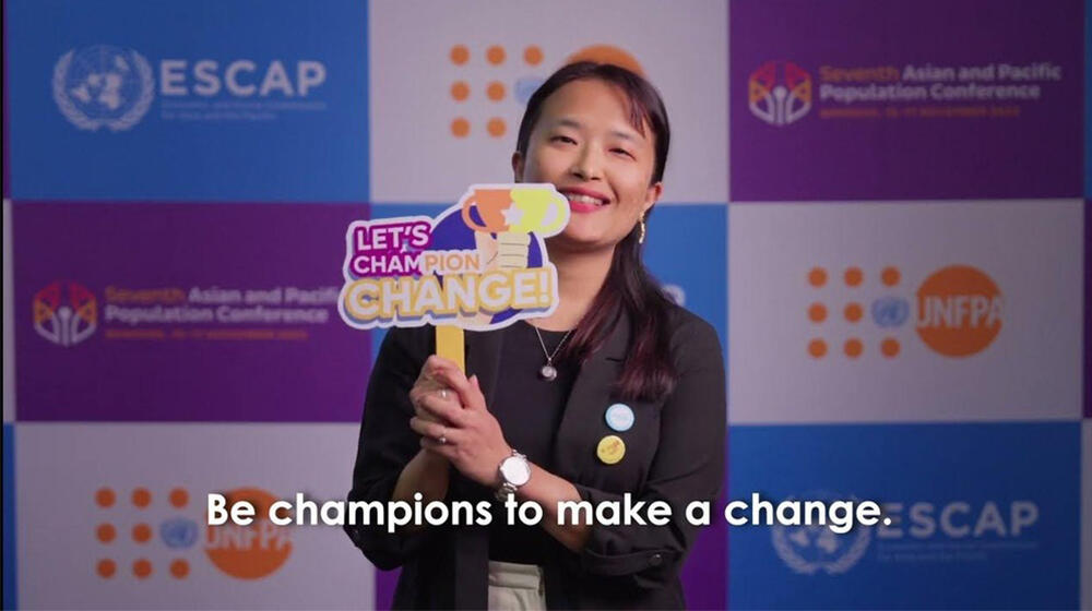 woman holding sign that reads let’s champion change