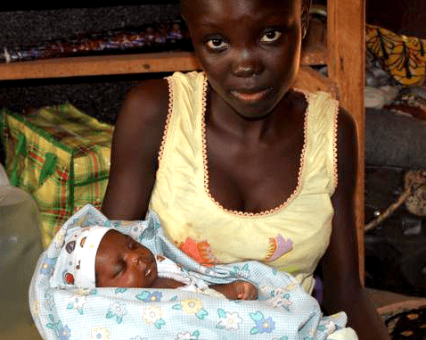 A young woman holds her infant son.