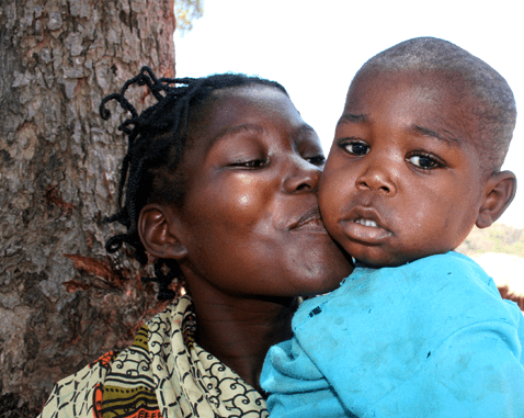 A woman kisses her son on the cheek.