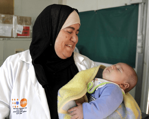 A UNFPA midwife holds a baby.