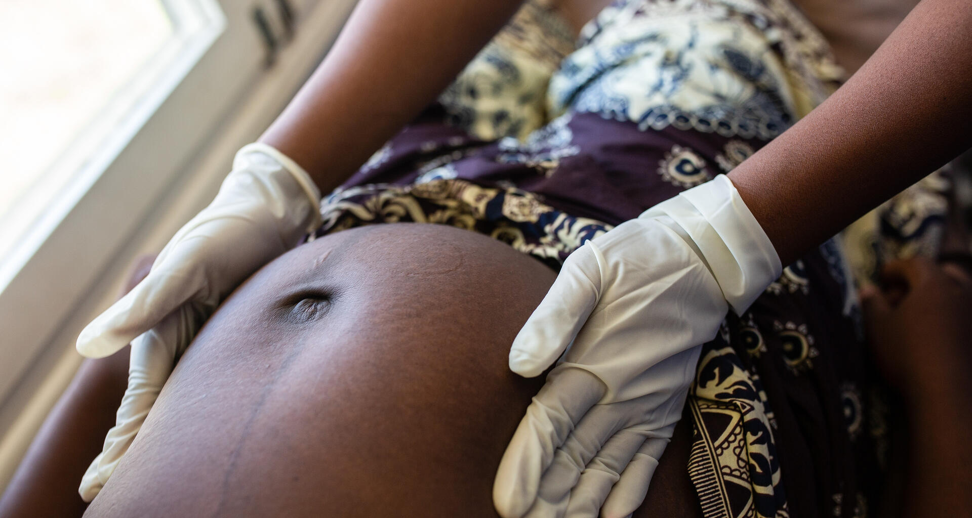 Un trabajador médico examina a una mujer embarazada.