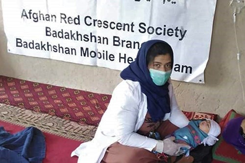 A midwife attends to a newborn and mother in rural Afghanistan.