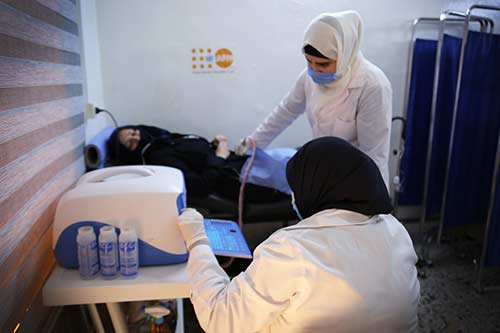 Medical workers perform an ultrasound on a woman in a UNFPA-supported clinic.