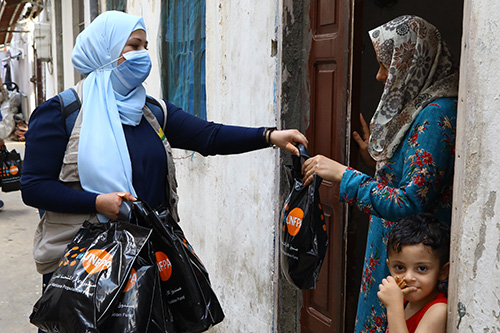 A woman in a blast-affected neighbourhood receives a dignity kit containing hygiene supplies. 