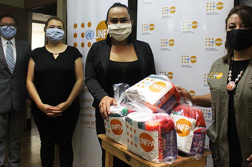 UNFPA staff stand beside kits intended for delivery to key populations.