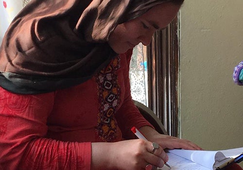 Salimeh writes in a notebook.