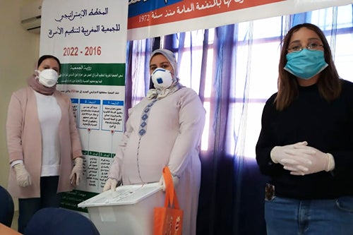 Youth advocates from the Y-Peer network stand wearing protective face masks and gloves.