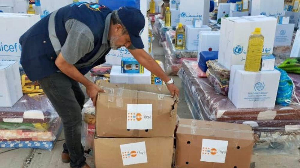 Un travailleur de l’UNFPA soulève un carton de fournitures humanitaires.