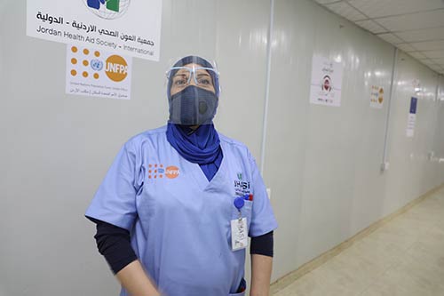 Un trabajador de la salud en PPE se encuentra en el centro de salud.