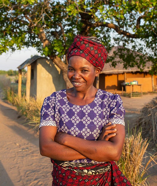 Une femme se tenant devant une maison.