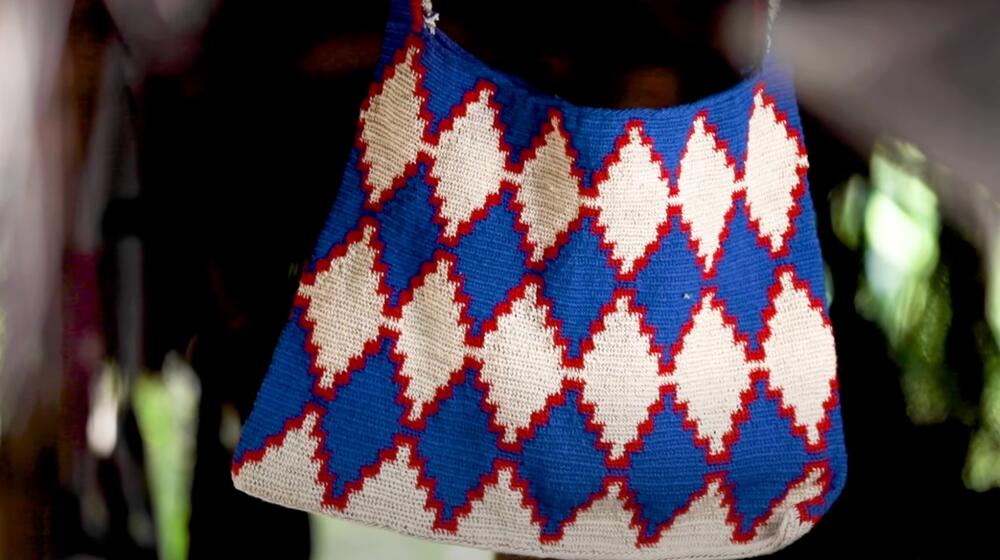 A bilum bag with shape patterns in blue and red.