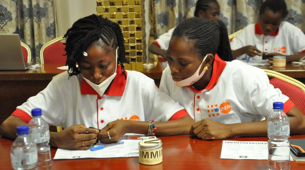 Two girls examine a watch during a workshop in Burkina Faso.