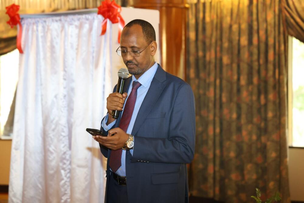 Dr. Bashir Issak holds a microphone and addresses participants at the launch of the ASRH DIB in Nairobi.