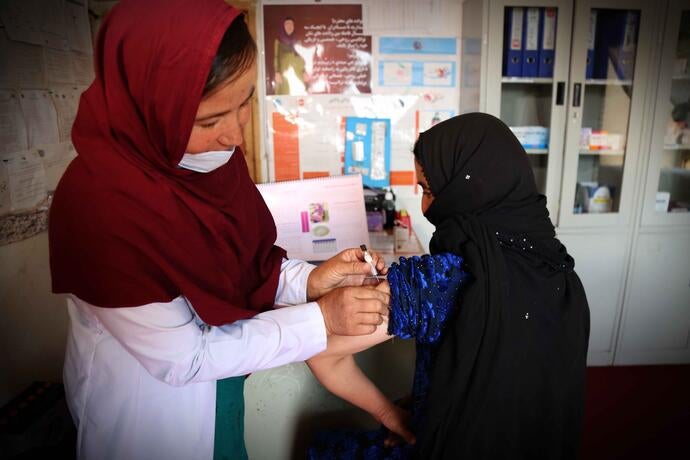 A women provides a health service to another woman.