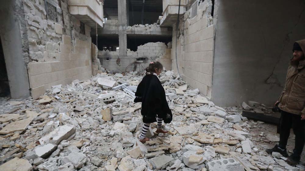 A girl child is seen among damaged buildings in Afrin district of Aleppo