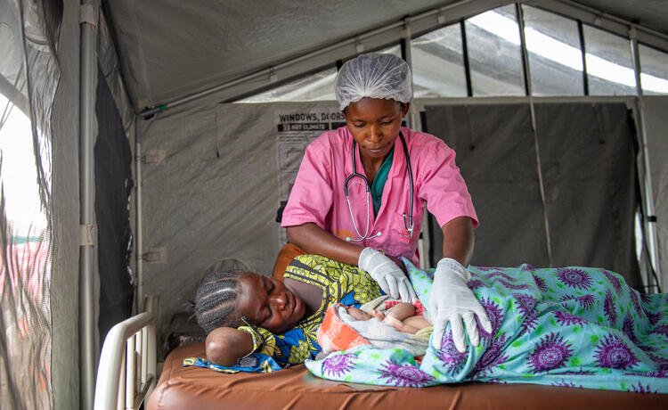 A midwife attends to a mother and her newborn. 