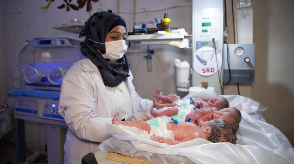 A health worker cares for 4 newborn babies.