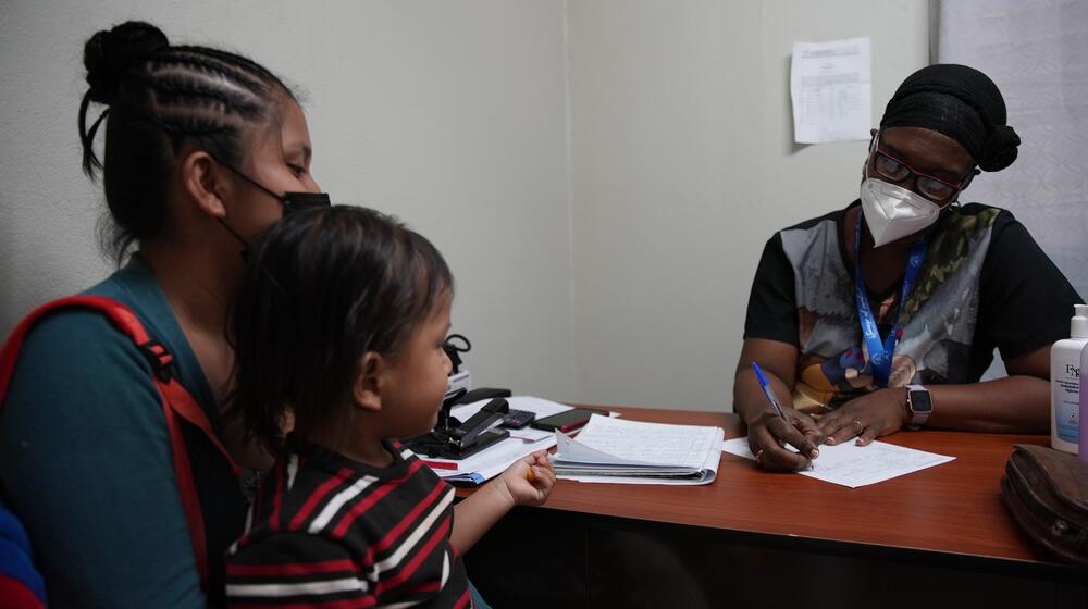 A woman and her child talk to a doctor in an office.