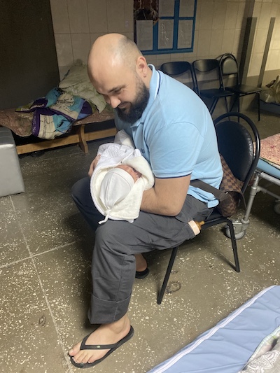Un homme porte un bébé.
