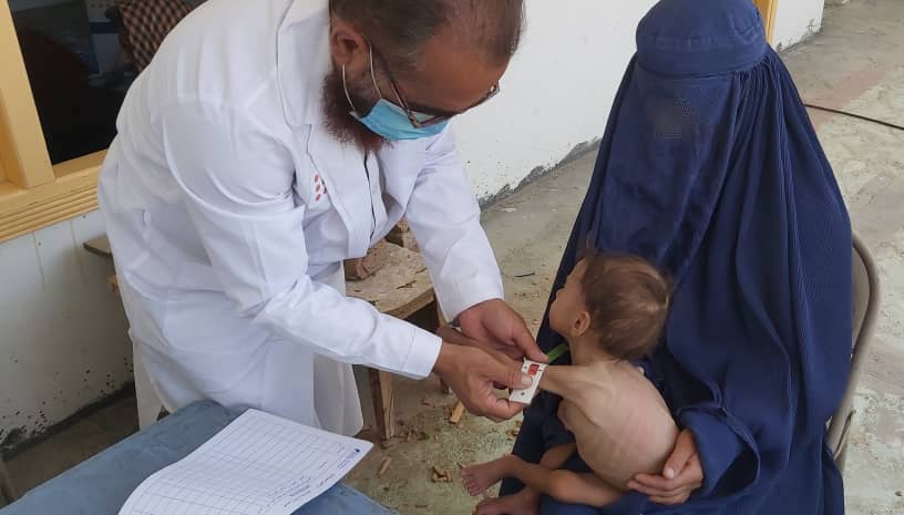A child is examined by a health worker.