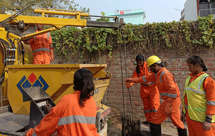 Trabajadoras de saneamiento de Patna limpian una alcantarilla de manera segura usando el nuevo sistema mecanizado.