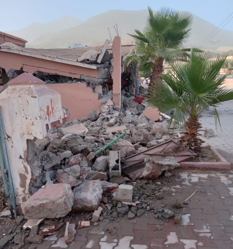 Rubble surrounds a collapsed building.