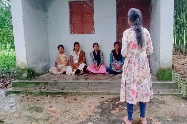 Girl with back turned talking to four other girls