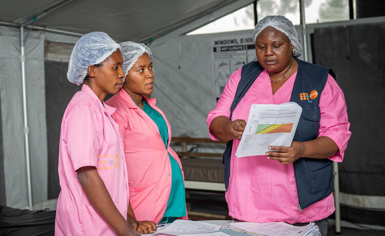 A team of three midwives stand together at the Bulengo IDP camp.
