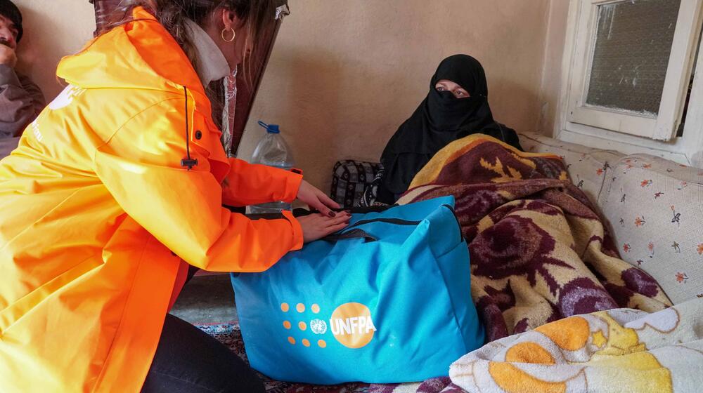 A woman receives supplies from UNFPA staff.