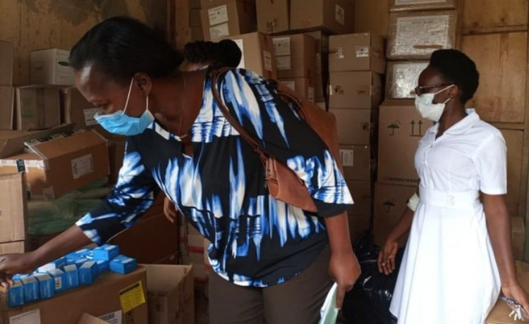 UNFPA Programme Analyst (Family Planning) Ms Roselline Achola inspects some of the reproductive health commodities supported by UNFPA during a spot-check exercise.