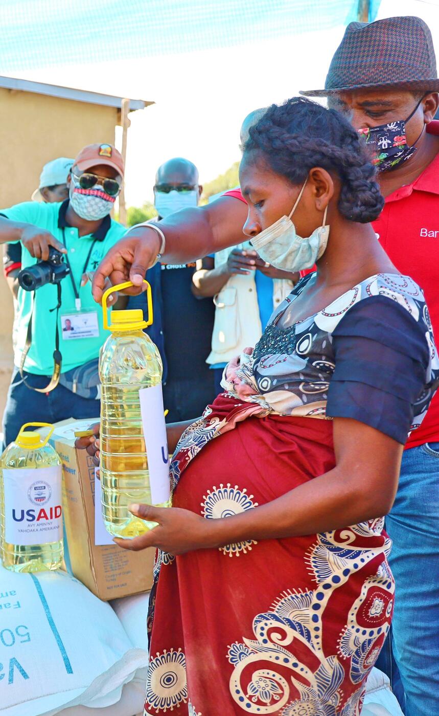 Une femme reçoit des rations d'huile et de nourriture.