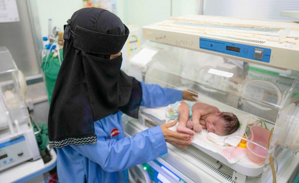 A medical worker cares for a newborn child.
