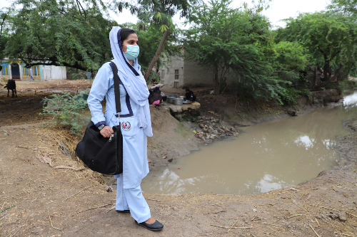 Midwife walking on road to make a housecall