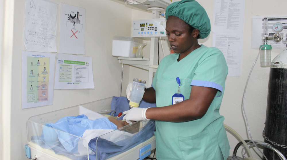 Midwife Clementine Uwumukiza attends to a baby in an incubation crib.