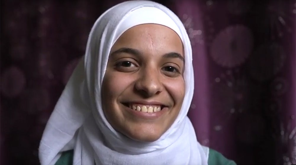 Yanal, a Syrian refugee in Jordan, smiles broadly.