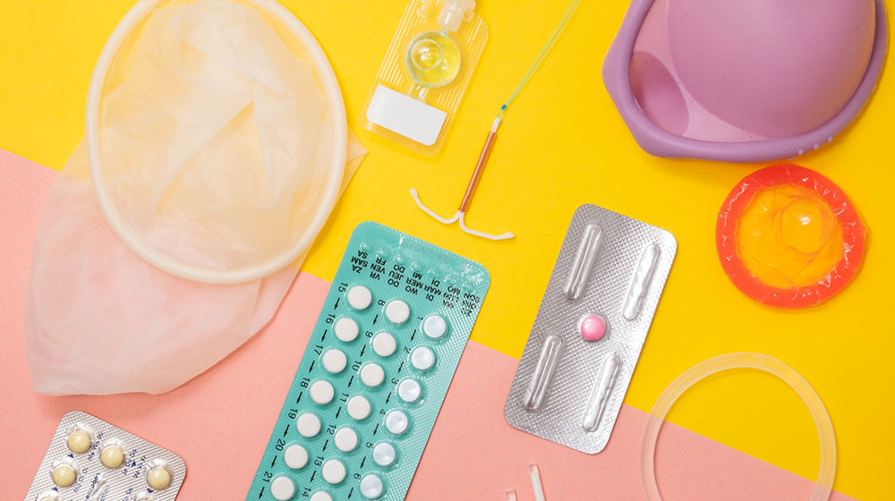 Contraceptive supplies are arranged against a yellow and pink background.
