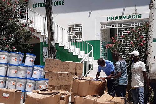 A man signs for a delivery of hygiene supplies outside a health facility in Haiti.