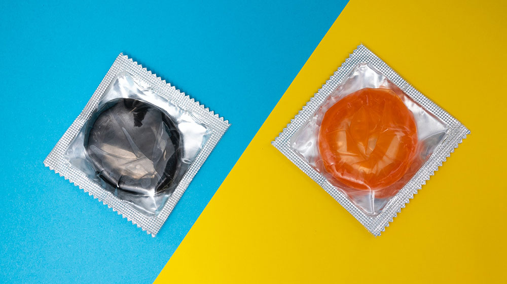 A photo shows a close up of condoms against a blue and yellow background.