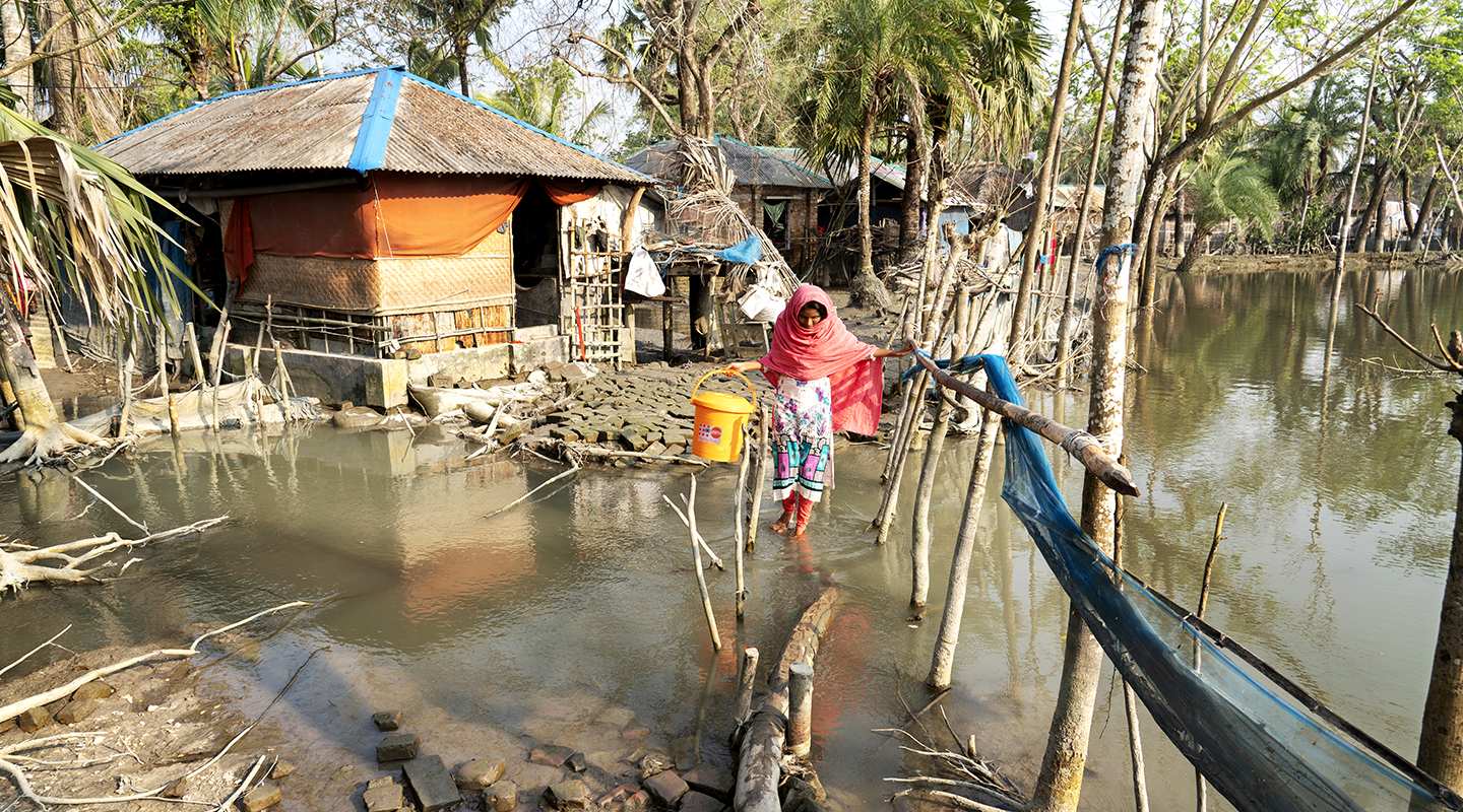 Farzana wades through floodwaters in Uttar-Bedkashi in the Khulna District. 