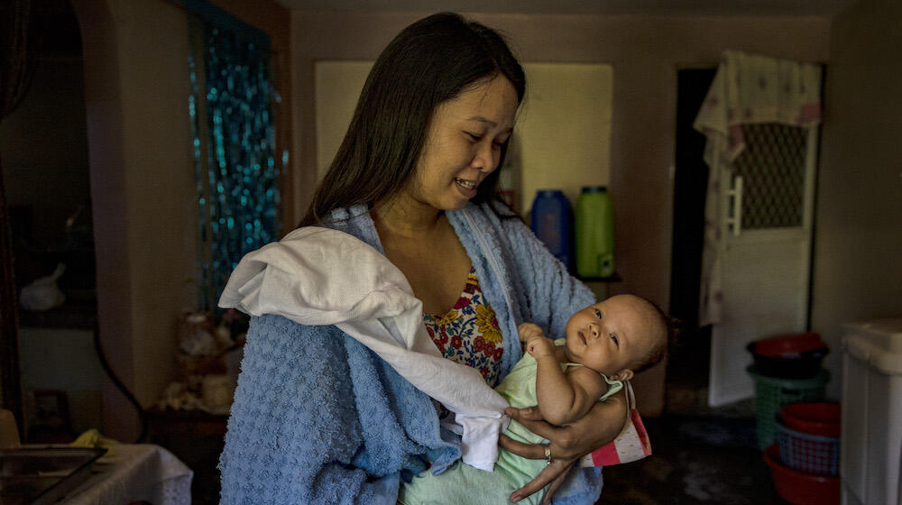 A woman holds an infant. 
