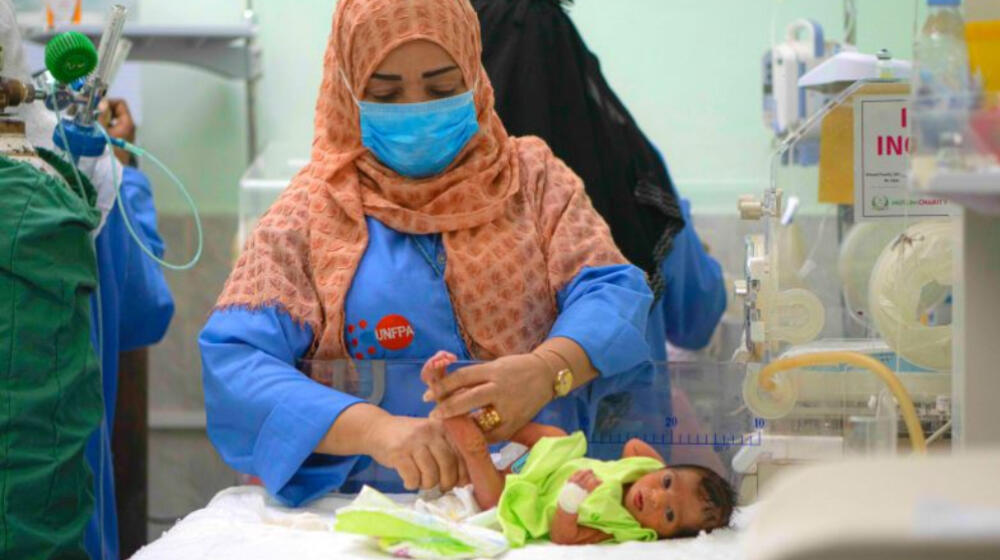 A nurse attends to a newborn child.